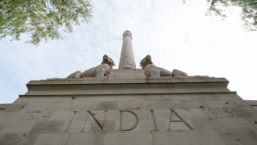 Central Indian-style column rising from the pediment of the Neuve-Chapelle Memorial. The words "1914 India 1918" are carved into the pediment. It is topped by two lion statues with the lions in repose.