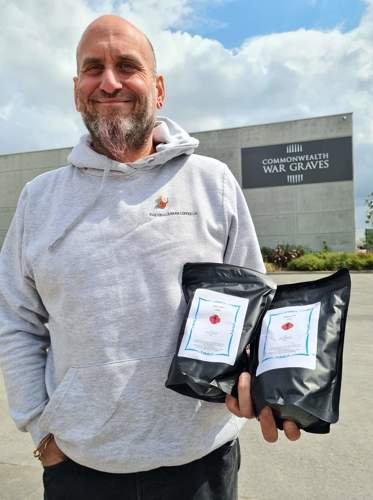 Rod Nesbit of Devil's Bean poses with Tommy's Brew coffee bags.