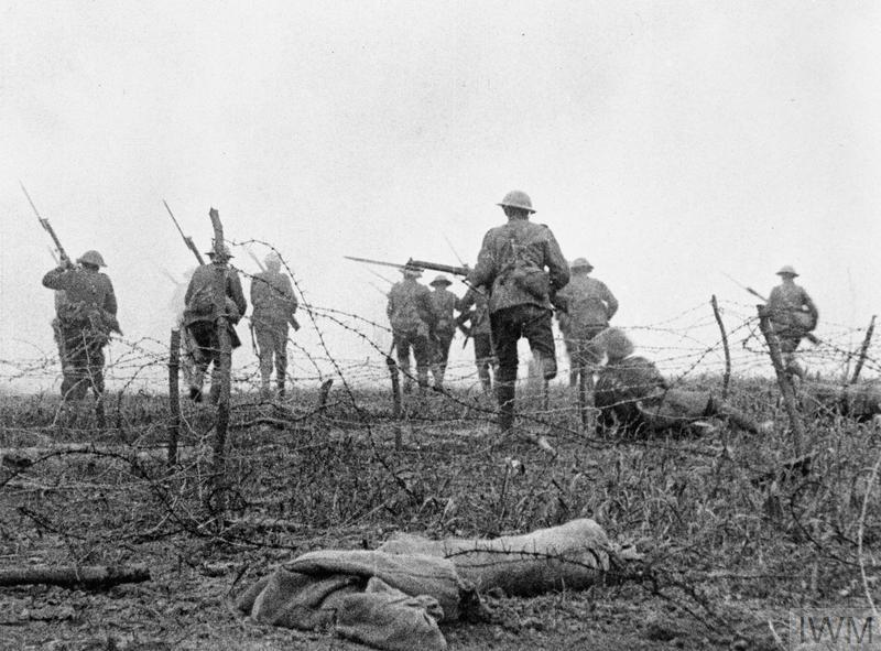 British soldiers advance through barbed wire into No Man's Land during the Battle of the Somme