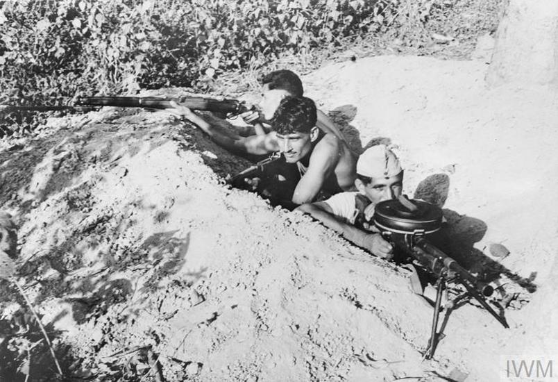 Indian soldiers man a trench with Bren guns in Burma.