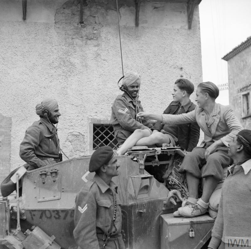Indian Army soldiers meet with Italian children on the back of a Sherman tank in Italy, circa 1943.