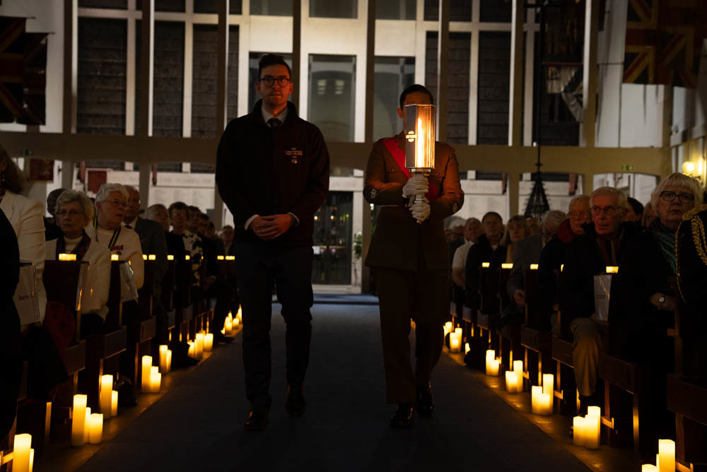 CWGC Pec and an Army Cadet esort the Torch of Commemoration up the candle lit aisle of the Guards' Chapel London