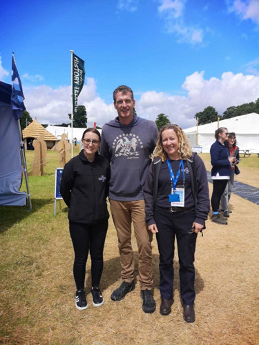 Two women pose with Dan Snow at a festival