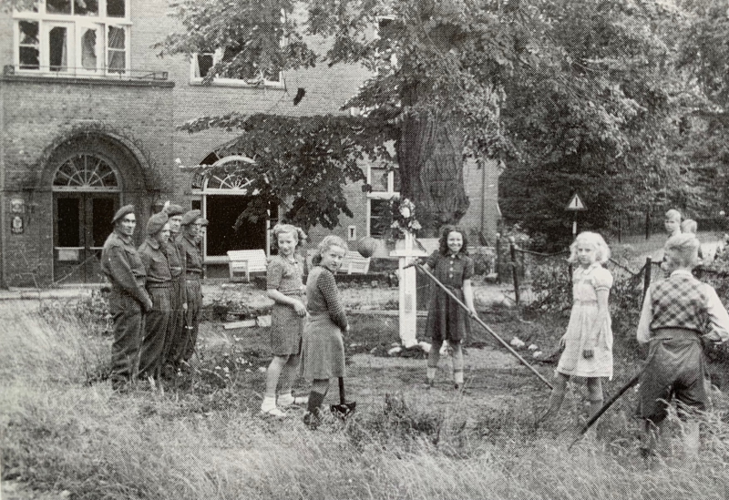 Young Dutch girls maintaining the war graves outside the Tafelberg Hotel, Arnhem, circa 1945. A group of British soldiers is watching the girls at work.