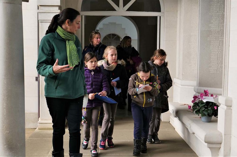 A guide shows a group of Brownies around the Runnymede Memorial.