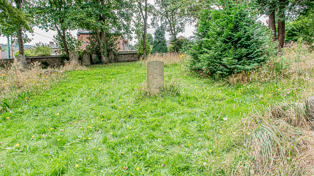 Isolated war grave of Private Ralph Reather. The headstone sits solo amidst long grass.