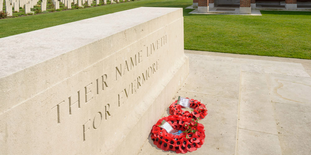 Stone of Remembrance with red poppy wreathes laid on the stone's steps.