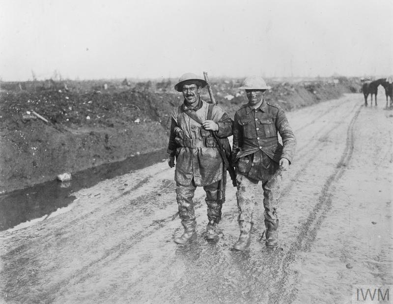 Two muddy Canadian soldiers walking along a muddy road at the Battle of the Somme.