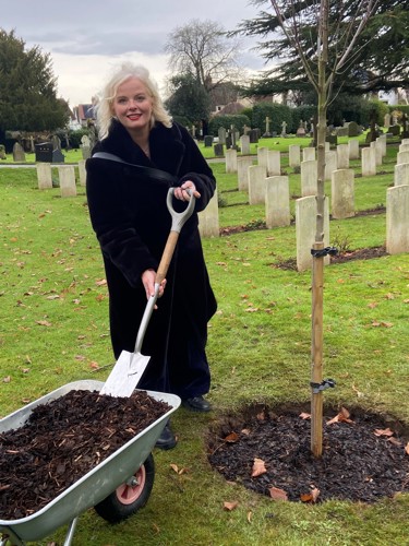 Maple Leaf trustee poses with a shovel after planting a maple leaf.