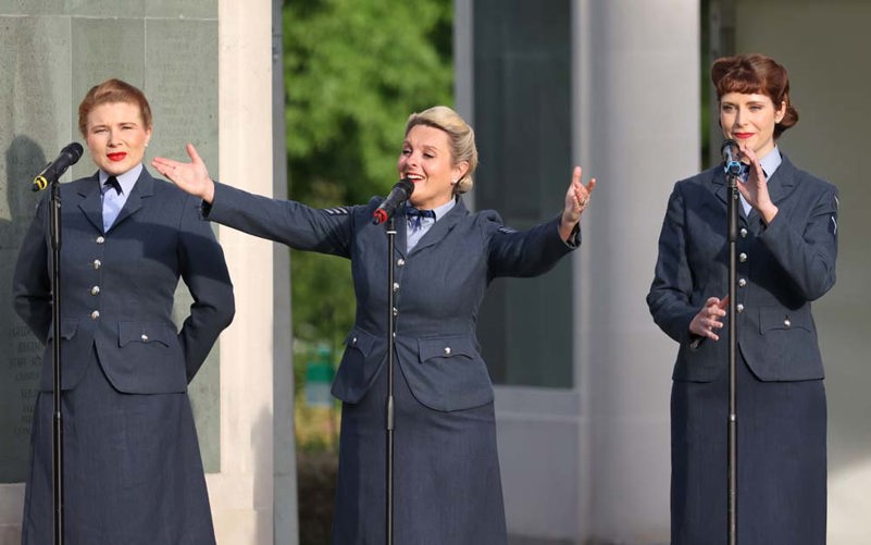 The D-Day Darlings girl group performing at Brookwood Military Cemetery in period 1940s WAAF uniforms.