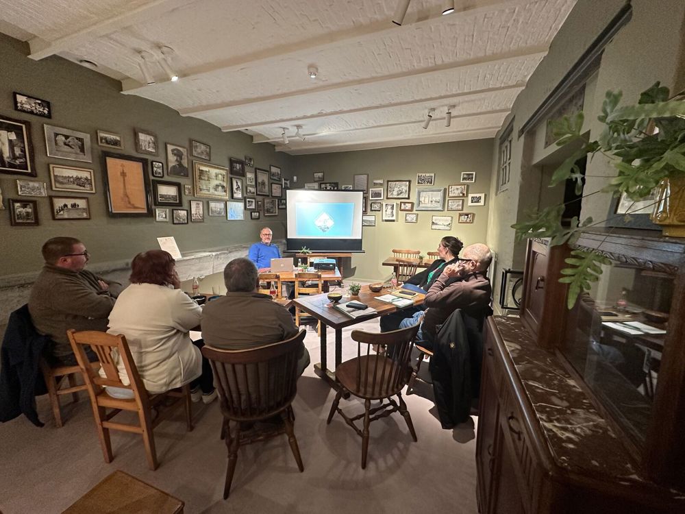 CWGC volunteers listen to a powerpoint presentation at the visitor centre in Ieper.