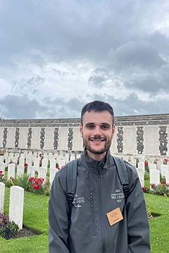 CWGF Guide Cole Green standing in front of war graves at Tyne Cot Cemetery.