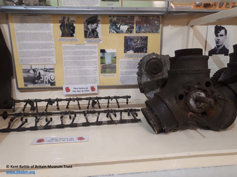 Museum display showing damaged components of a Battle of Britain Spitfire as well as photographs of the airmen.